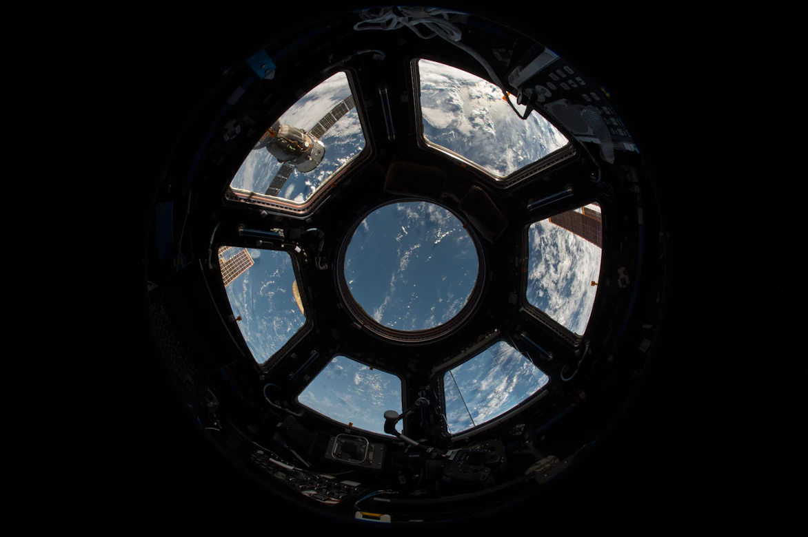 Hublot d'une station spatiale ouvert sur la Terre